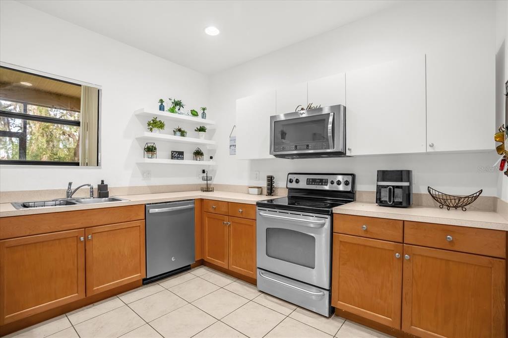 1374 Pacific Road Poinciana, FL 34759 - Photo 13 of 42 a kitchen with stainless steel appliances granite countertop a sink and cabinets