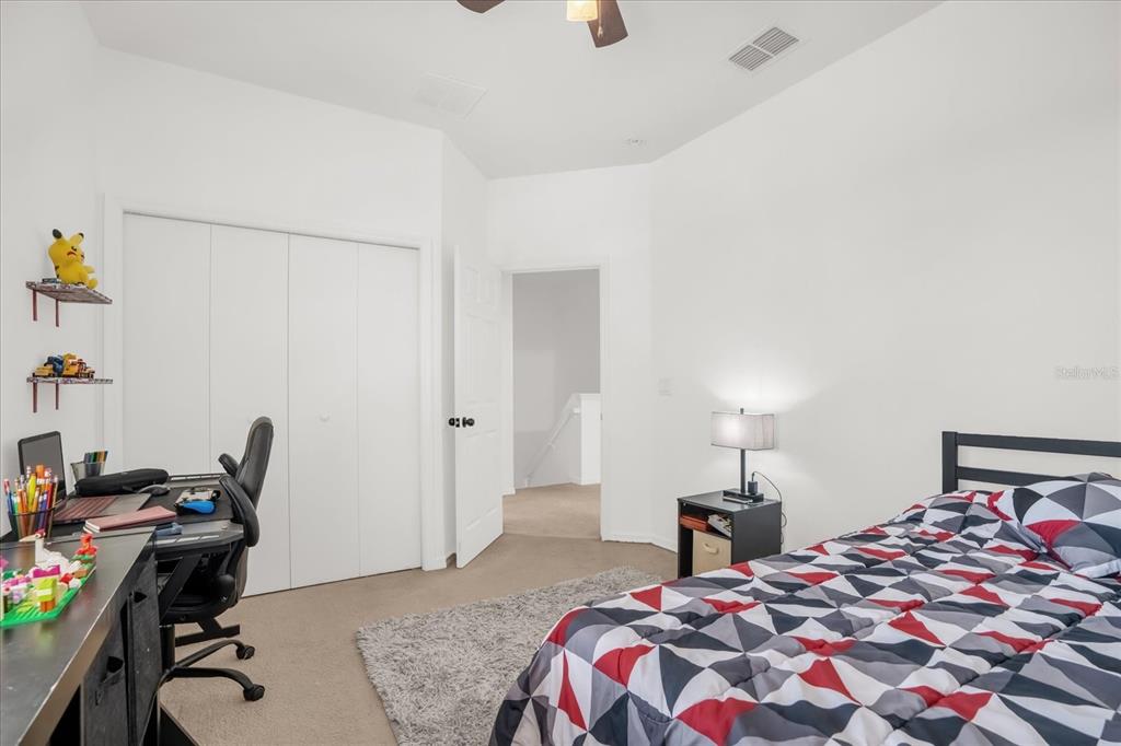 1374 Pacific Road Poinciana, FL 34759 - Photo 25 of 42 a bedroom with a bed and a desk