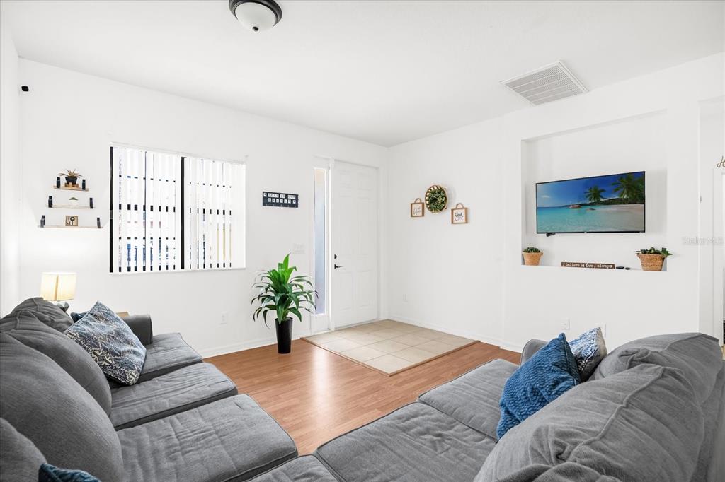 1374 Pacific Road Poinciana, FL 34759 - Photo 7 of 42 a living room with furniture and a flat screen tv