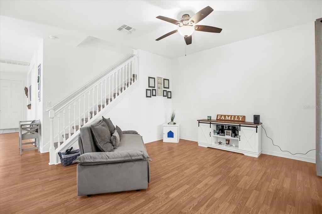 1374 Pacific Road Poinciana, FL 34759 - Photo 8 of 42 a living room with furniture and a wooden floor