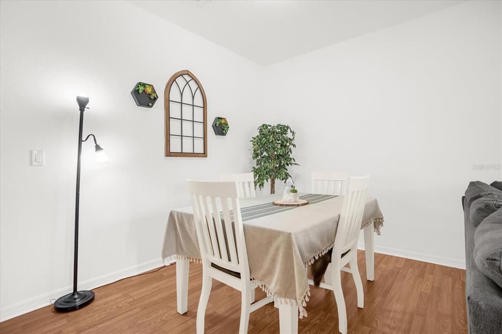 1374 Pacific Road Poinciana, FL 34759 - Photo 10 of 42 a view of a dining room with furniture and wooden floor