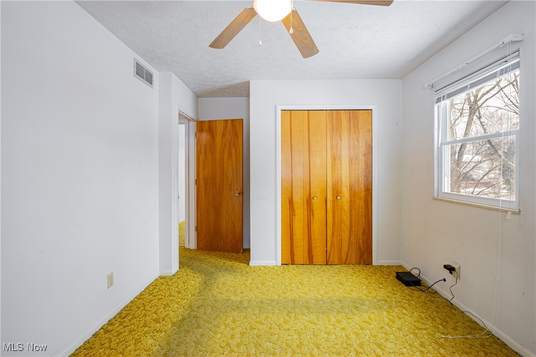 5905 Renninger Road New Franklin, OH 44319 - Photo 14 of 31 Unfurnished bedroom with carpet, ceiling fan, a textured ceiling, and a closet