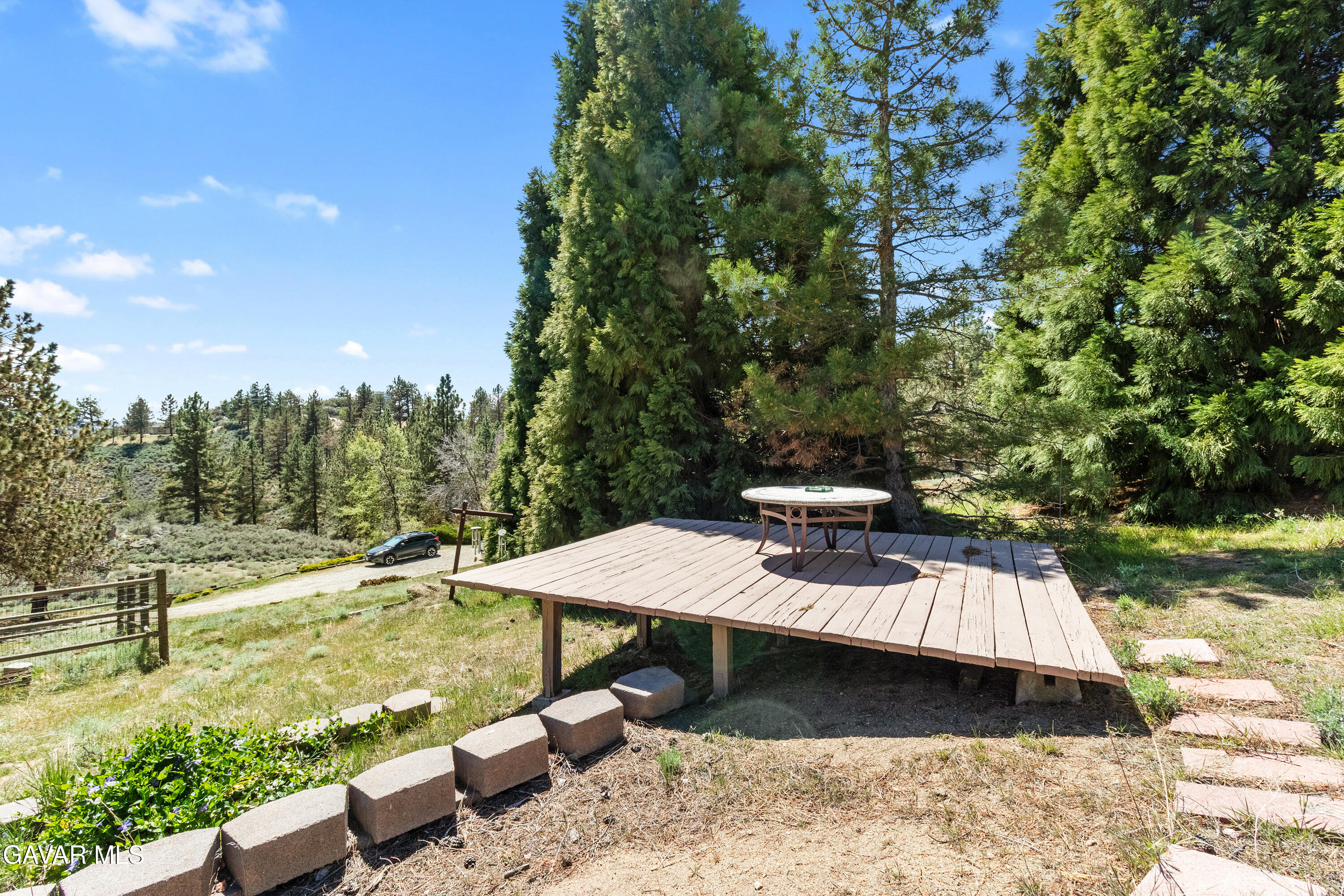 25631 High Rock Court Tehachapi, CA 93561 - Photo 27 of 31 a view of a patio with lawn chairs plants and large trees