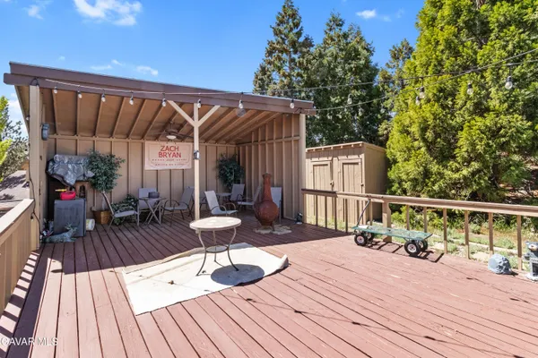 a balcony with wooden floor table and chairs