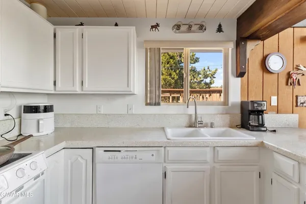 a kitchen with stainless steel appliances granite countertop a sink a window and cabinets
