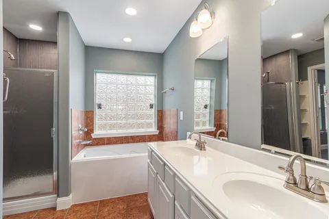 a bathroom with double vanity and a bathtub