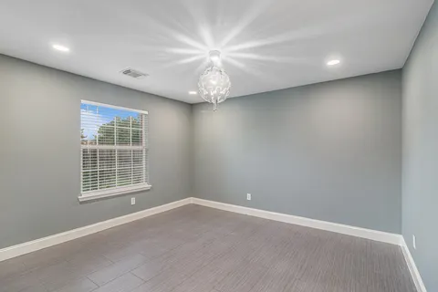 en empty room with windows and ceiling fan