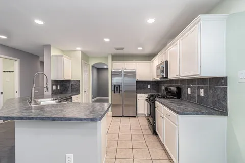 a kitchen with stainless steel appliances granite countertop a sink and cabinets