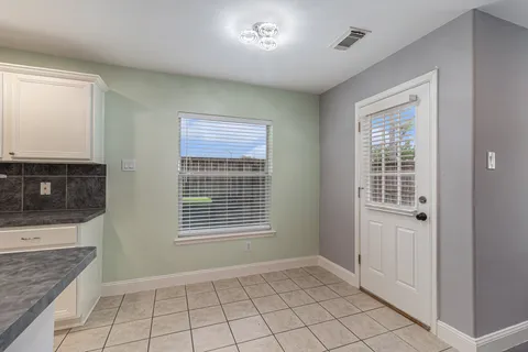 a view of an empty room with a fireplace and a window