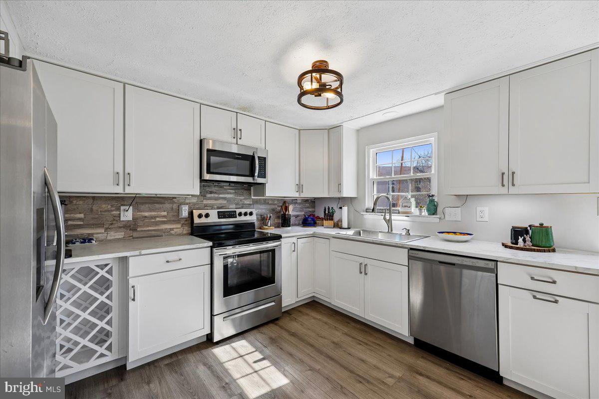 1476 Dockside Court Frederick, MD 21701 - Photo 3 of 34 a kitchen with stainless steel appliances granite countertop a sink and a stove top oven