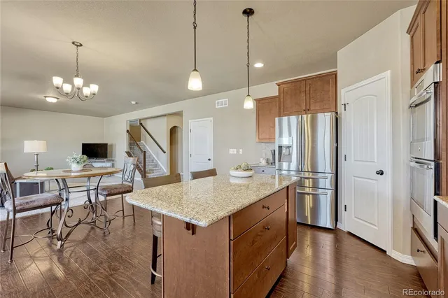a kitchen with stainless steel appliances granite countertop a stove refrigerator and cabinets