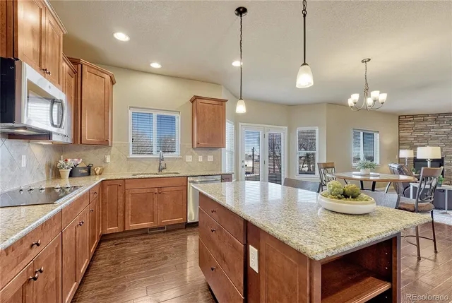 a kitchen with stainless steel appliances granite countertop a sink a stove and microwave
