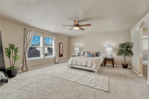 a bedroom with a large bed and a chandelier