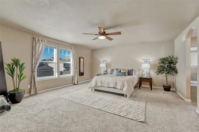 a bedroom with a large bed and a chandelier