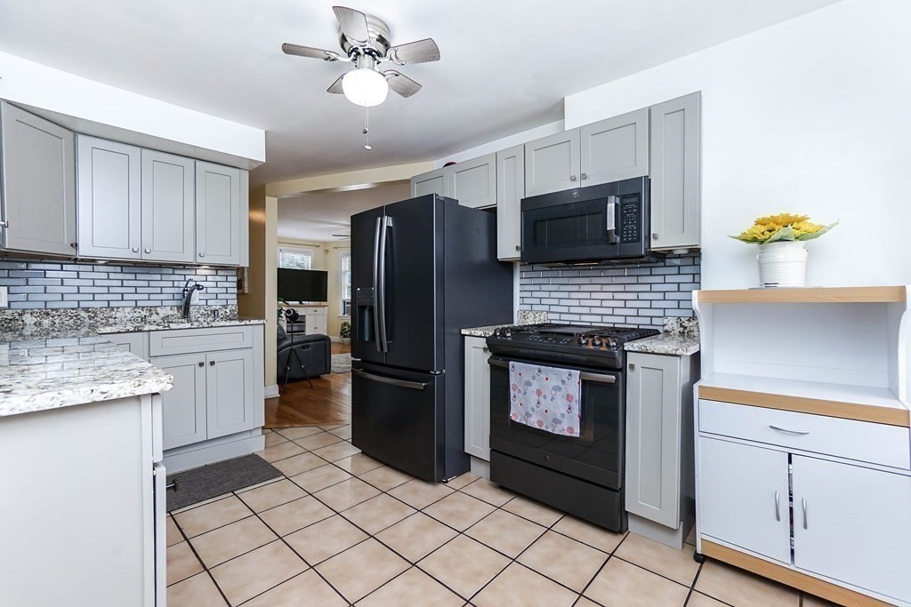 291 Carter Street Chelsea, MA 02150 - Photo 15 of 40 a kitchen with granite countertop a refrigerator stove and microwave