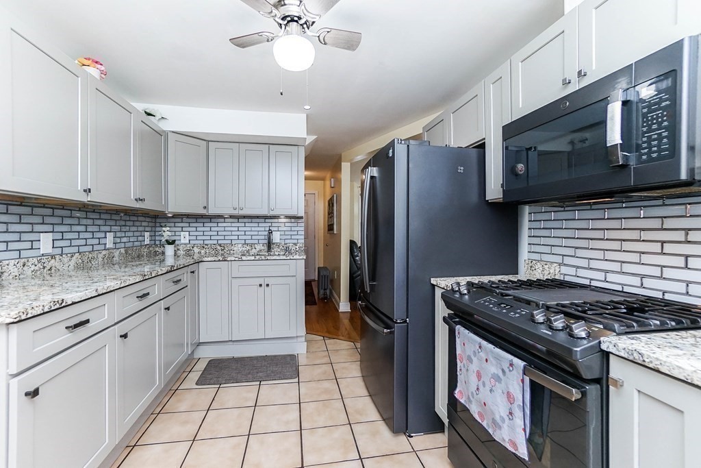 291 Carter Street Chelsea, MA 02150 - Photo 16 of 40 a kitchen with granite countertop a stove sink and cabinets