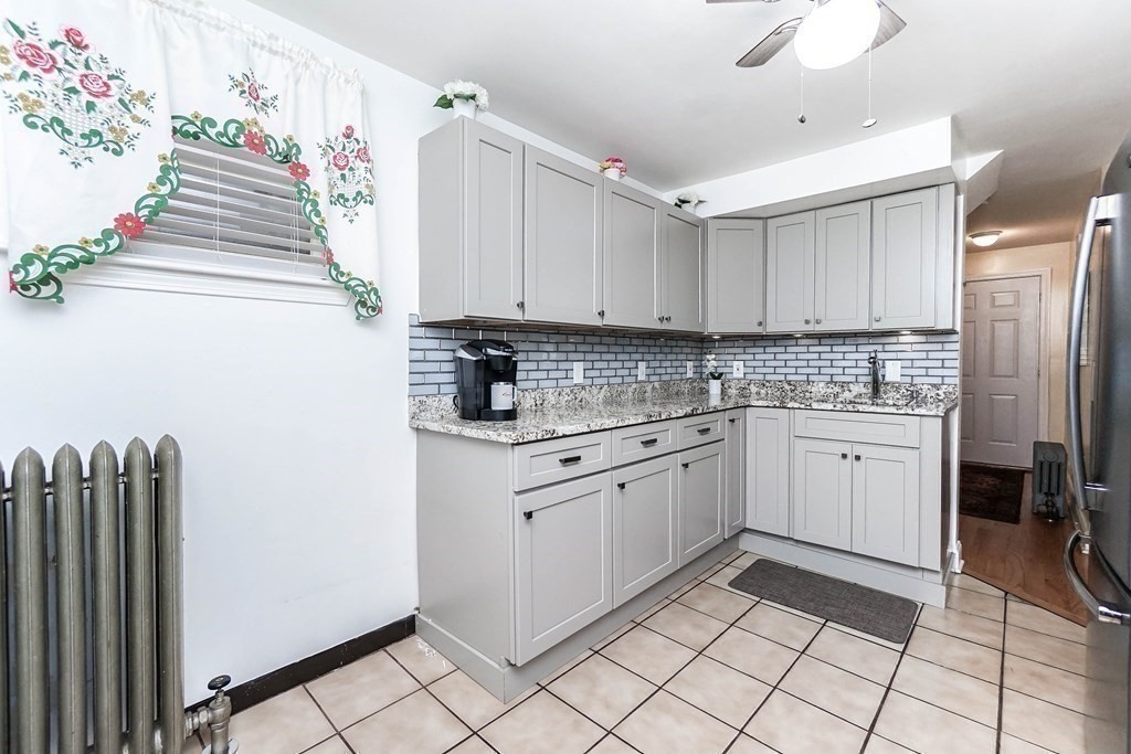 291 Carter Street Chelsea, MA 02150 - Photo 17 of 40 a kitchen with granite countertop white cabinets and white appliances