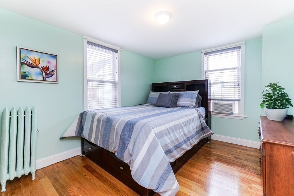 291 Carter Street Chelsea, MA 02150 - Photo 22 of 40 a bedroom with a bed and wooden floor