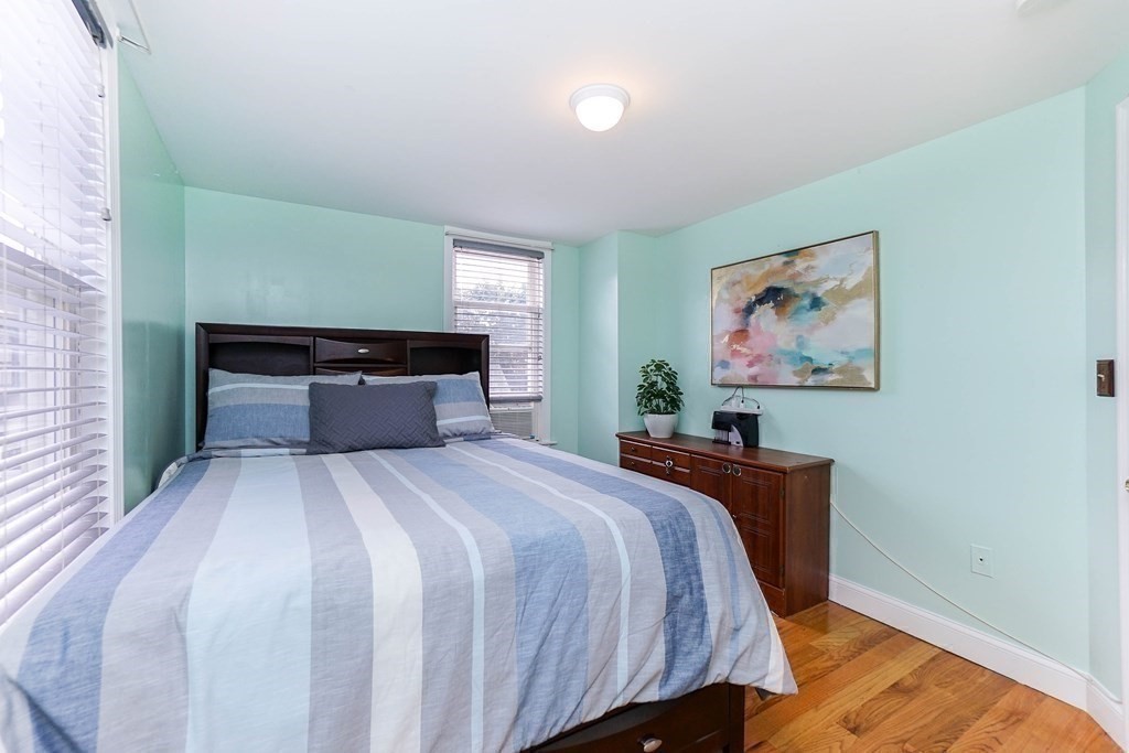 291 Carter Street Chelsea, MA 02150 - Photo 23 of 40 a bedroom with a bed and wooden floor