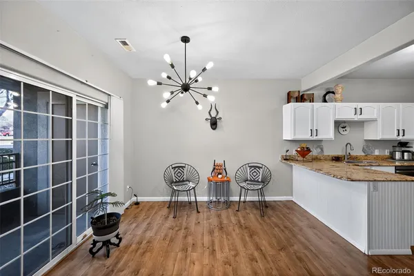a living room with furniture kitchen view and a wooden floor
