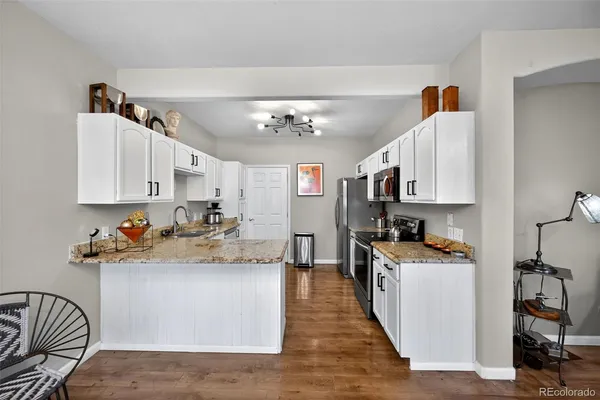 a kitchen with stainless steel appliances granite countertop a sink stove and refrigerator