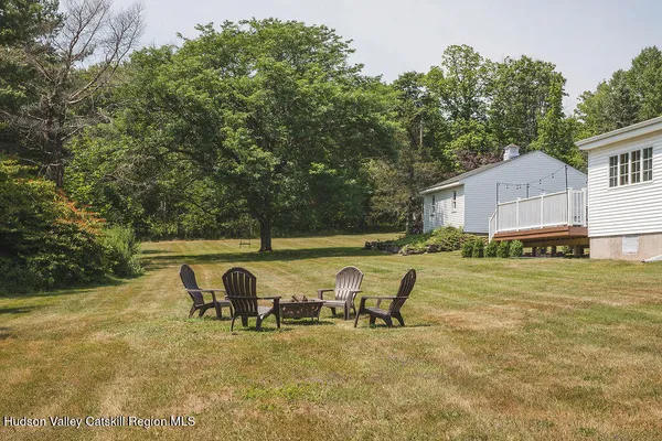 a view of backyard with swimming pool and seating space
