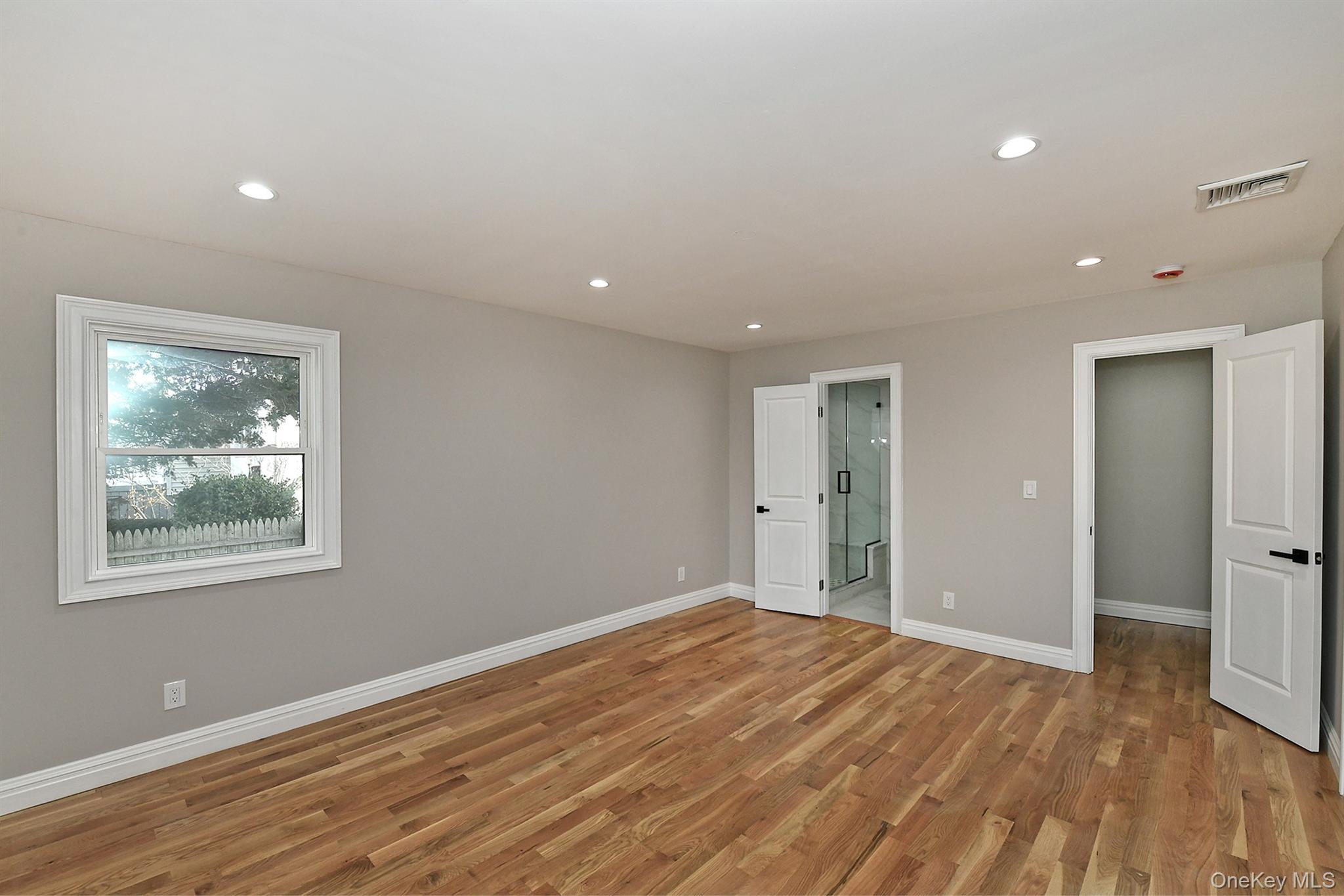 1903 George Court Merrick, NY 11566 - Photo 22 of 39 a view of an empty room with wooden floor and a window