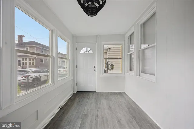 a view of a room with wooden floor and windows