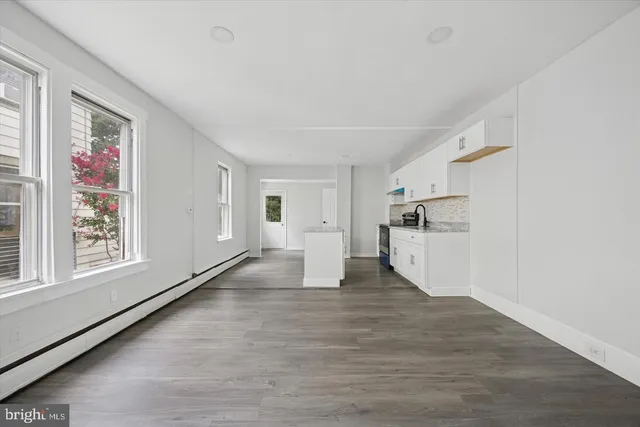 a view of empty room with wooden floor and window