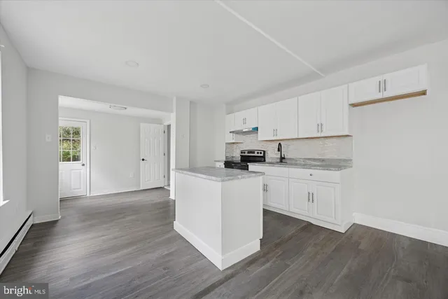 a kitchen with granite countertop white cabinets and white appliances