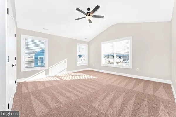 an empty room with ceiling fan and window