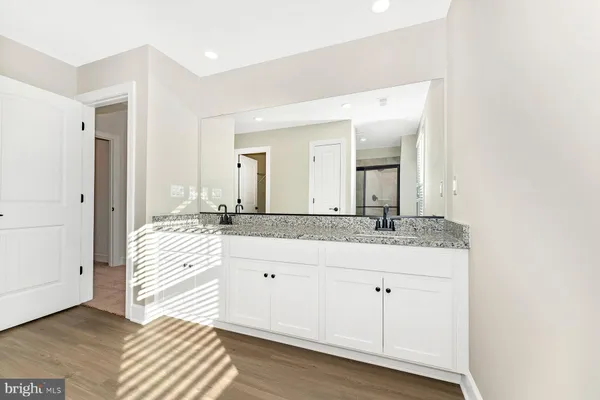 a spacious bathroom with a granite countertop sink and a mirror