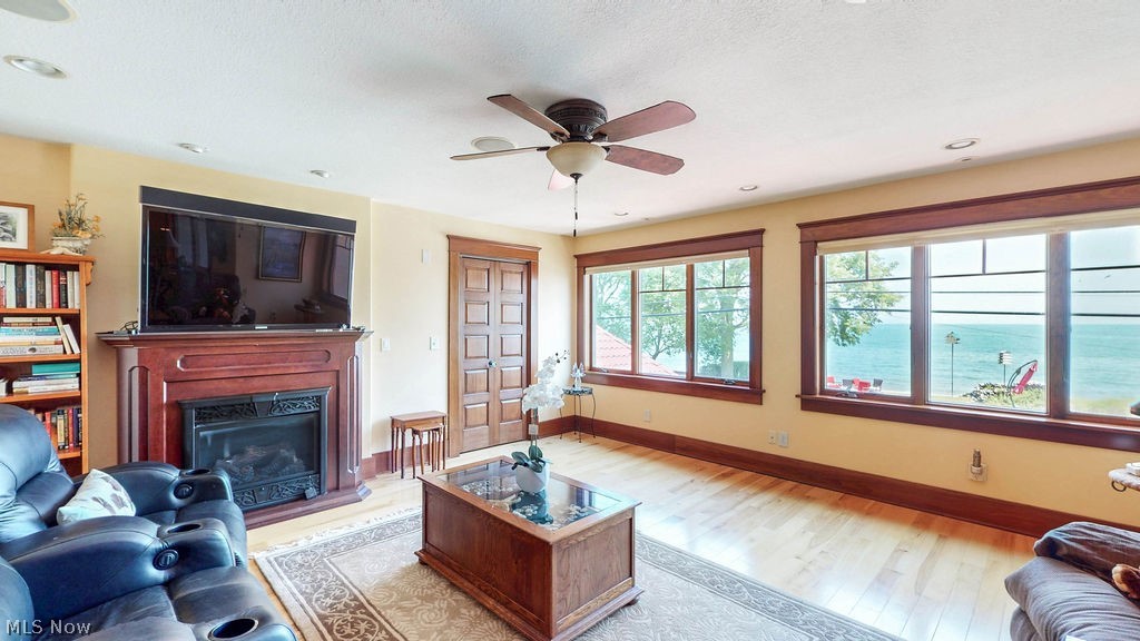 1431 Cedar Point Road Sandusky, OH 44870 - Photo 27 of 50 Living area featuring light wood finished floors, a fireplace with raised hearth, ceiling fan, and recessed lighting