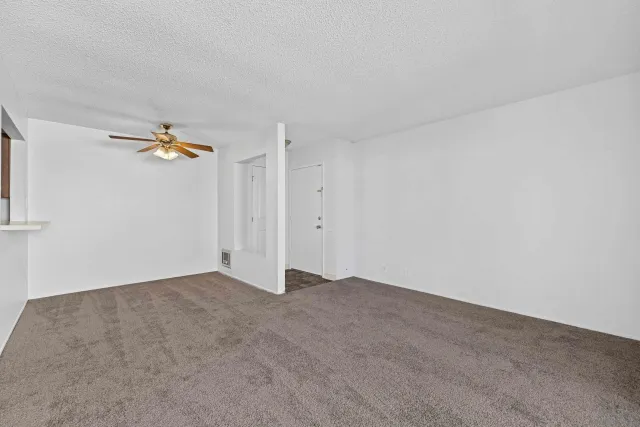 an empty room with closet and fan