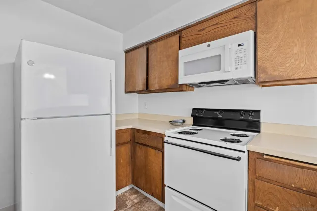 a view white cabinets a sink and dishwasher