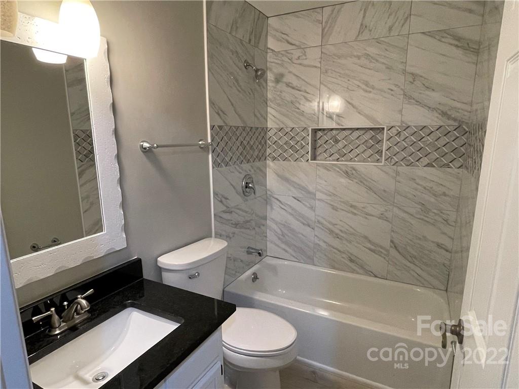 20105 Henderson Road, Unit E Cornelius, NC 28031 - Photo 21 of 23 a bathroom with a granite countertop toilet sink and shower