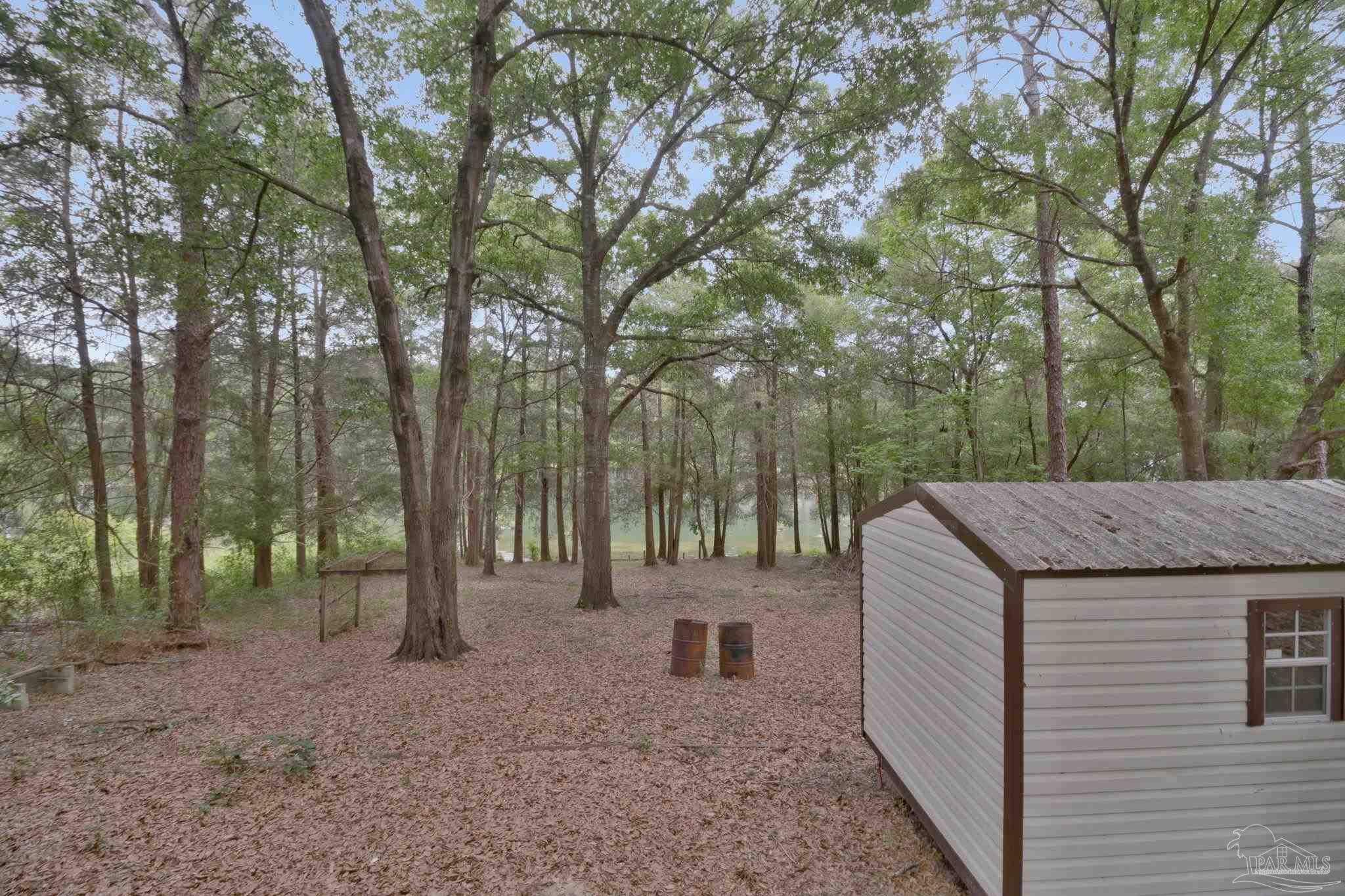 10290 West Lake Road Milton, FL 32583 - Photo 26 of 53 a view of a backyard with trees