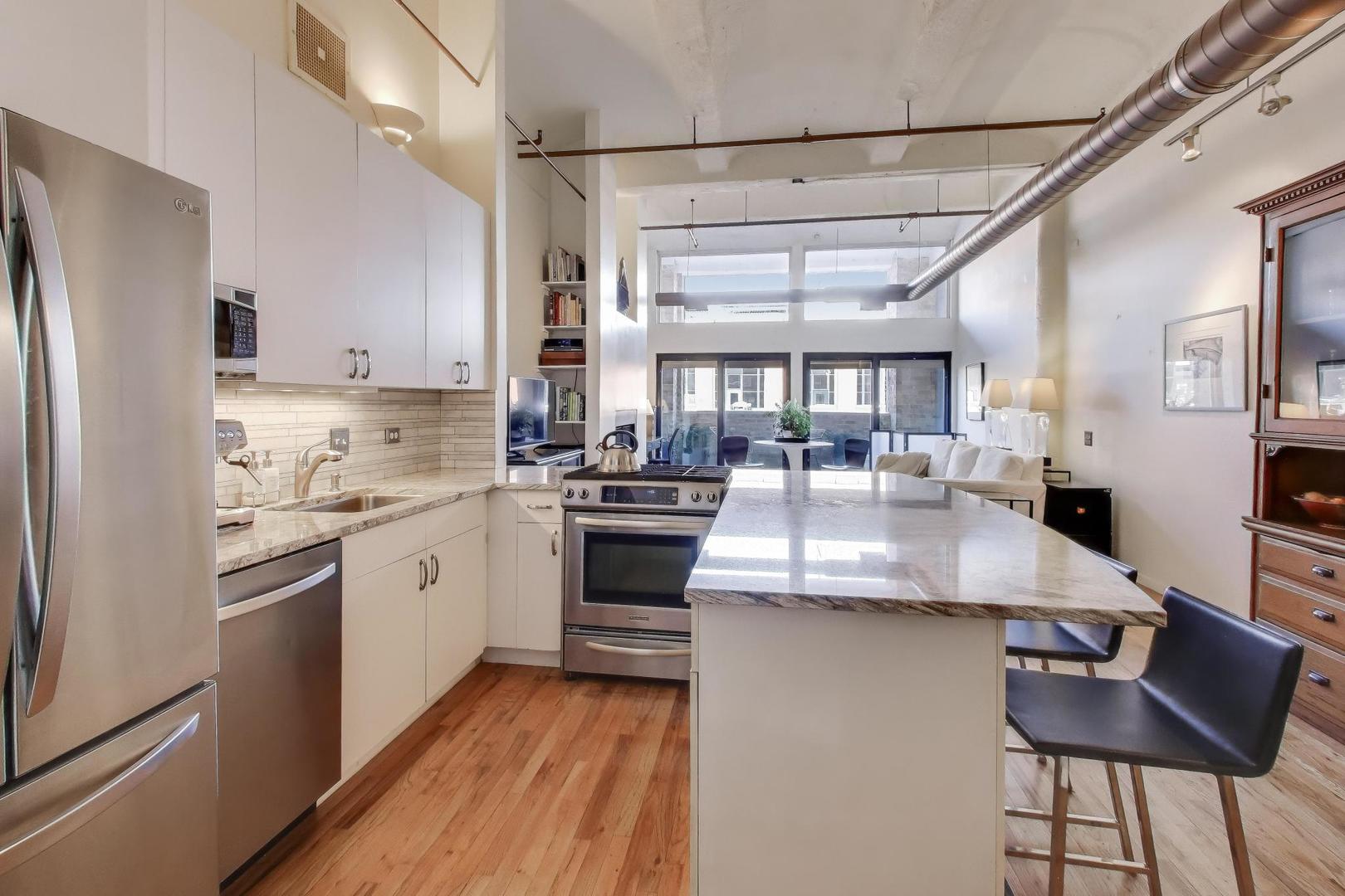 1000 West Washington Boulevard, Unit 418 Chicago, IL 60607 - Photo 12 of 20 a kitchen with stainless steel appliances granite countertop a sink stove and refrigerator