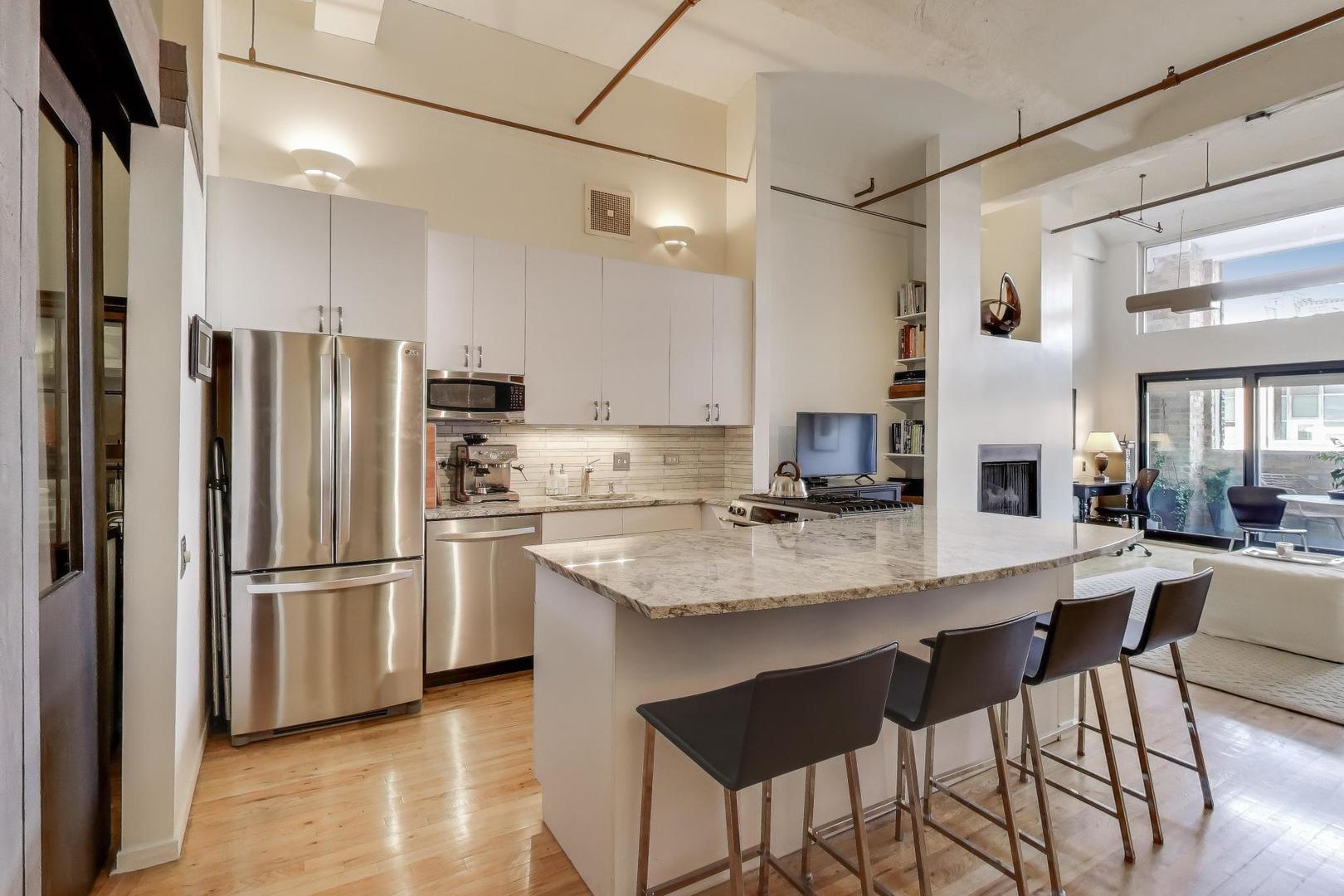 1000 West Washington Boulevard, Unit 418 Chicago, IL 60607 - Photo 10 of 20 a kitchen with stainless steel appliances granite countertop a refrigerator and a stove top oven