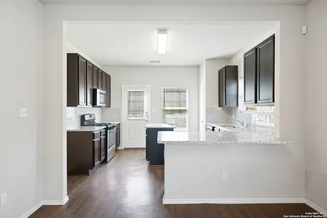 a large kitchen with cabinets and wooden floor