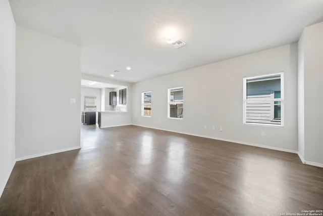 a view of a livingroom with wooden floor and windows