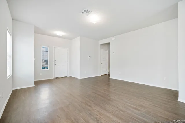 a view of an empty room with wooden floor