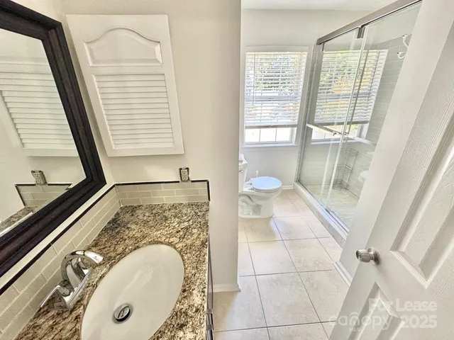 a bathroom with a granite countertop sink and a mirror