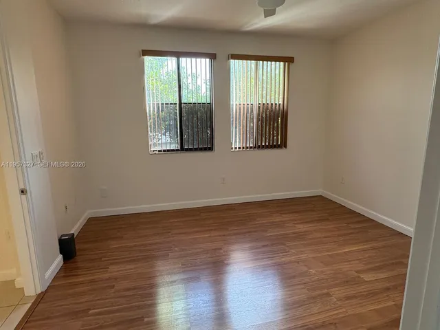 a view of an empty room with wooden floor