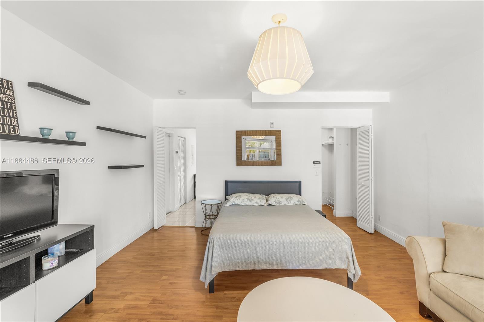 1241 14th Street, Unit 9 Miami Beach, FL 33139 - Photo 11 of 19 a bedroom with a bed and a flat screen tv