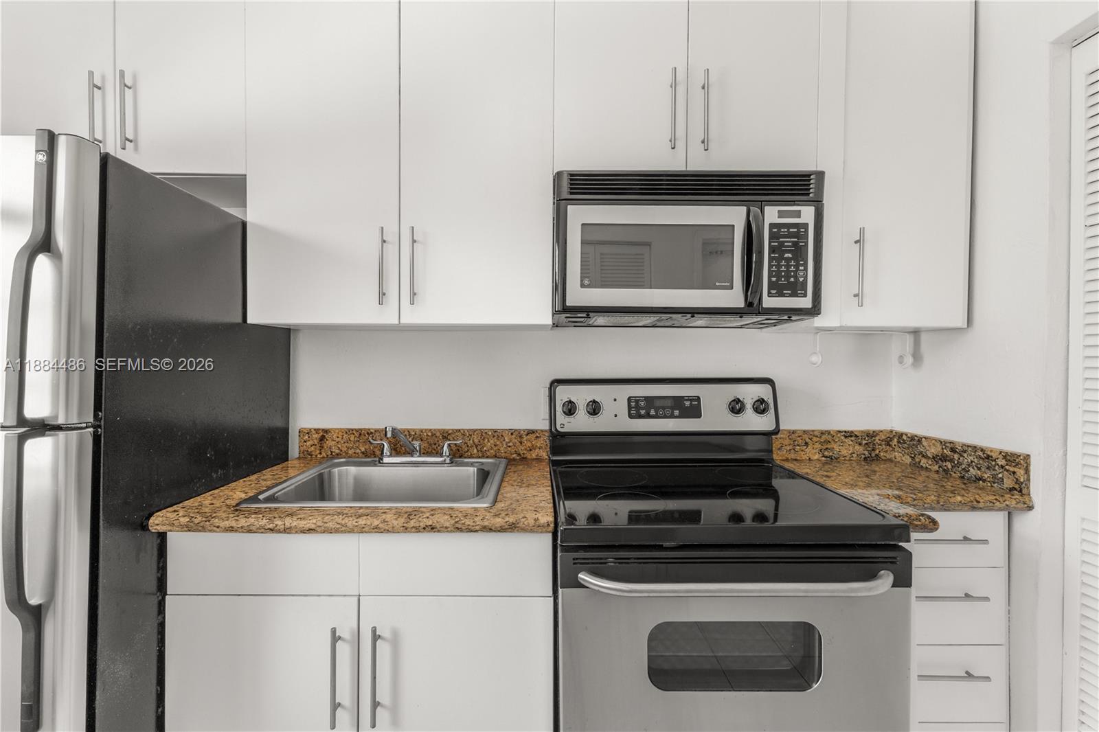 1241 14th Street, Unit 9 Miami Beach, FL 33139 - Photo 14 of 19 a kitchen with a stove and a microwave