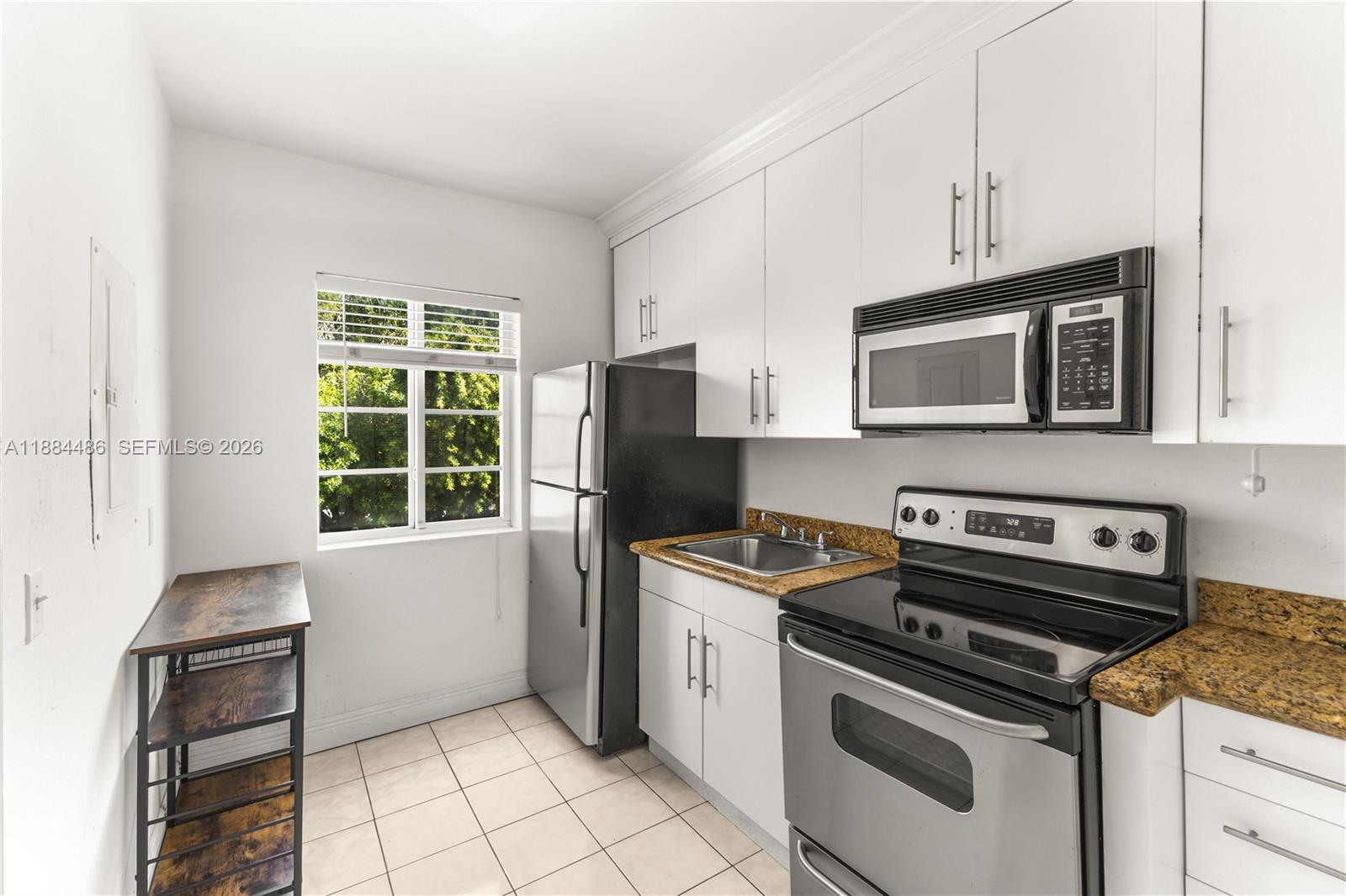 1241 14th Street, Unit 9 Miami Beach, FL 33139 - Photo 15 of 19 a kitchen with a stove a sink and a microwave