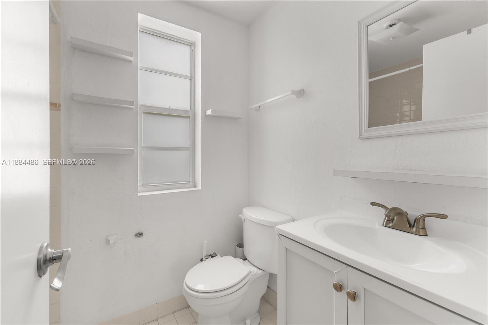 1241 14th Street, Unit 9 Miami Beach, FL 33139 - Photo 17 of 19 a bathroom with a sink toilet and a mirror