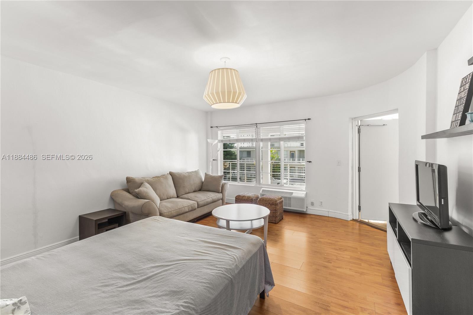 1241 14th Street, Unit 9 Miami Beach, FL 33139 - Photo 8 of 19 a bedroom with a bed flat screen tv and window