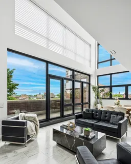 a living room with furniture floor to ceiling window and a floor to ceiling window